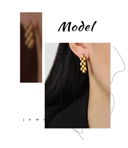 Detail view of gold-plated stainless steel interlocking chain drop earrings on model