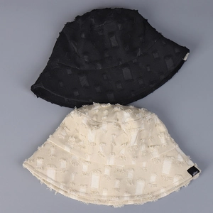 Détail de la texture usée et des franges sur les bobs noir et beige de style vintage