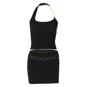 Détail d'un ensemble deux pièces noir avec chaînes dorées et mini-jupe assortie
