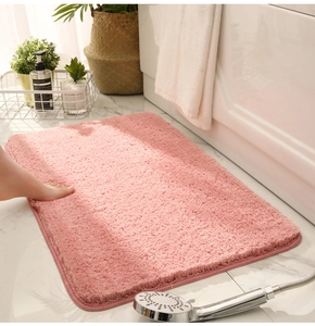 Close-up of pink plush bathroom mat with absorbent texture on marble floor