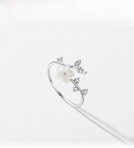 Macro shot of silver S925 shell camellia flower ring with sparkling zircon stones