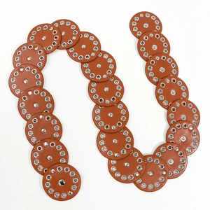 Detail of vintage brown leather belt with round discs, silver rivets and eyelet studs