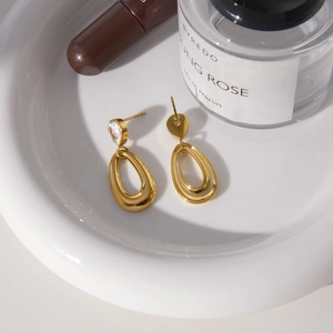 Elegante 18k vergoldete Edelstahl-Ohrringe mit Zirkon-Tropfen auf einer Keramikschale
