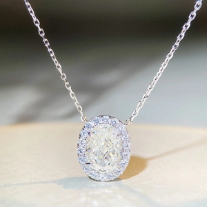 Close-up of sparkling oval-cut crystal pendant with halo setting and silver chain link