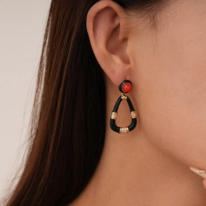Detail view of vintage teardrop earrings featuring black resin and gold zircon accents