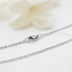 Fine silver titanium steel cable chain necklace with lobster clasp on white floral background