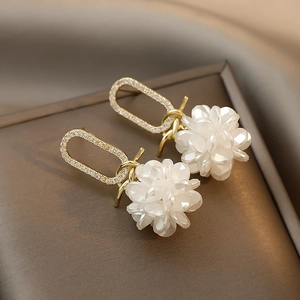 Detail of cluster flower earrings featuring white petals and sparkling rhinestones