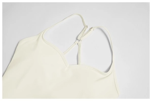 Détail du haut de yoga crème avec boucles réglables et fines bretelles de sport