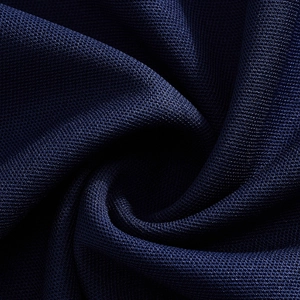 Macro detail of navy blue breathable honeycomb mesh fabric on a men's polo shirt