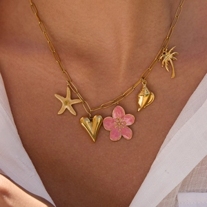 Detail of gold titanium necklace featuring starfish, heart, pink flower and seashell charms