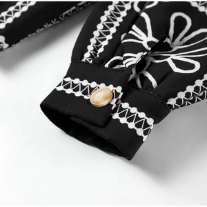 Detailed macro shot of black floral printed sleeve cuff with single resin button