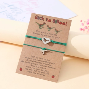 Detailed view of two green cord dinosaur bracelets on a Back to School themed card