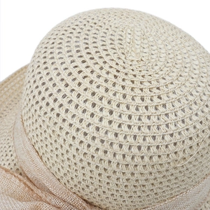 Macro shot of straw sun hat showing detailed spiral weave and linen ribbon texture