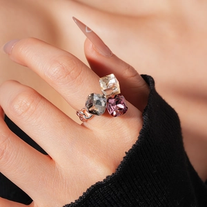 Macro view of three-stone square cut ring with champagne, grey and purple crystals