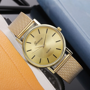 Close-up of golden Geneva quartz watch featuring brushed dial and metallic mesh band