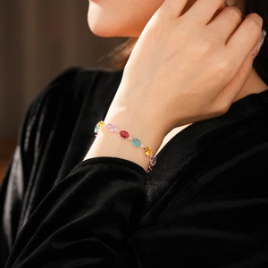 Close-up of multicolor oval zircon stones set in a silver bracelet on a model wrist