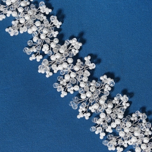 Handmade bridal headband with white pearls and crystals on a dark blue background