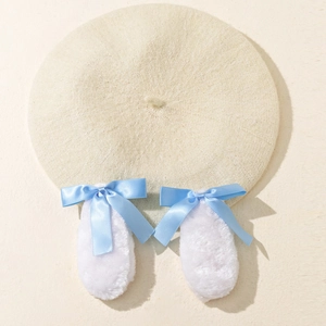 Béret en tricot beige avec des oreilles de lapin blanches et des nœuds en satin bleu