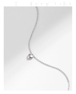 Macro shot of s925 silver beaded chain with a polished 3D heart pendant and smooth finish