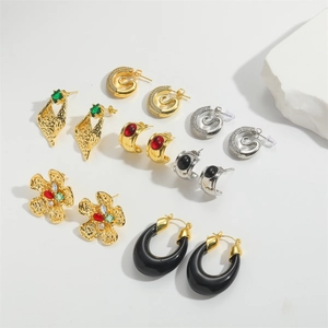 Detail shot of hammered retro flower earrings and octopus design zircon studs in gold and silver