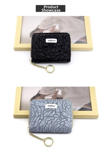 Detail of gray and black floral embossed mini wallets with gold zippers and keychains