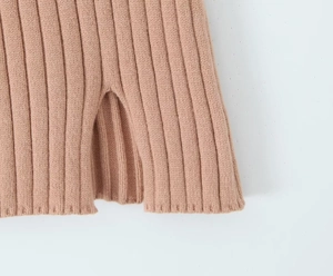 Detailed close-up of pink ribbed knit fabric featuring a stylish side slit design