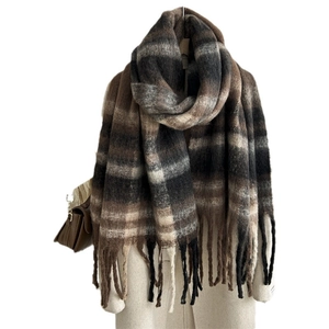 Thick mohair plaid scarf with tassels in brown and black on a light winter coat