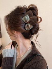 Close-up of brown velvet bow hair claw clip worn on model showing texture and warm autumn style