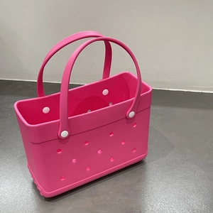 Detailed 45-degree angle of a pink waterproof EVA beach tote with holes for charms
