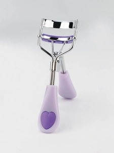 Detail of eyelash curler with purple heart handle and built-in comb for precise lash styling