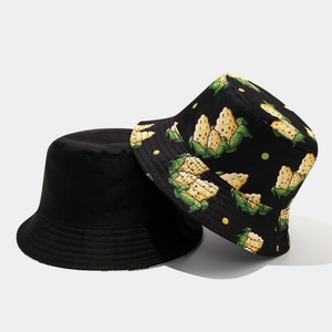 Detail of reversible cotton bucket hat showing plain black and cartoon corn pattern sides