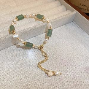 Detailed shot of adjustable gold bracelet with baroque pearls and green stone beads