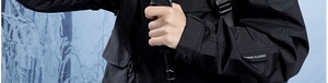 Close-up of waterproof black outdoor jacket sleeve with fashion patch and trekking pole