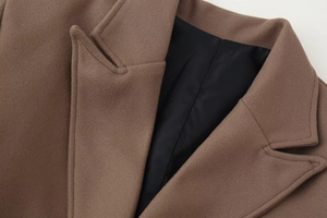 Detail of wool blend coat collar showing fine stitching and smooth black lining