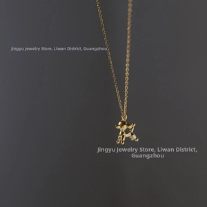 Detailed macro view of the polished 18K gold plated balloon dog pendant and fine chain