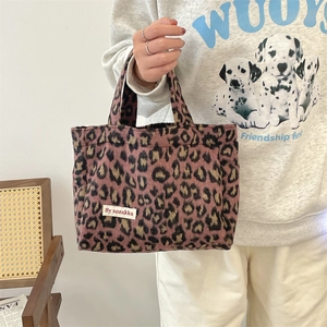 Detail of pink leopard print tote bag with soft plush texture and brand woven label