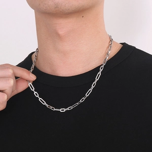 Close-up of a silver stainless steel paperclip chain necklace worn by a model