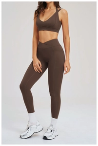 Dettaglio dei leggings da yoga marrone scuro con vita alta incrociata e tasche laterali