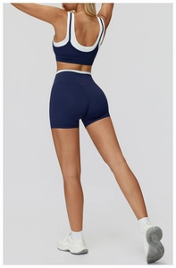 Detail view of the racerback sports bra and high-waisted shorts in navy with white trim