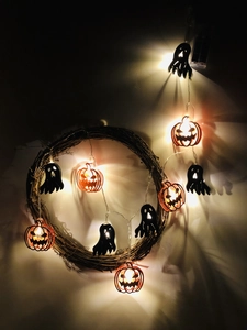 Detail of pumpkin and ghost LED string lights on a vine wreath for Halloween decor