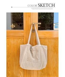 Detail of corduroy tote bag with front pocket showing soft vertical ribbed texture