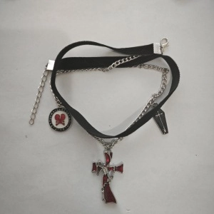 Detail view of double-layer gothic choker with red cross pendant and silver charms