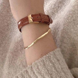Close-up of S925 sterling silver minimalist irregular bracelet paired with brown leather strap