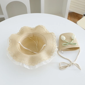 Close-up of straw sun hat and matching bag with lace trim and tulip decorations