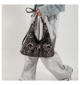 Close-up of leopard print tote bag with metal ring detail and functional zippers