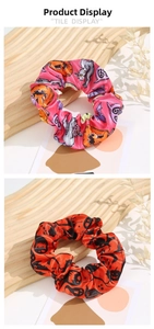 Detailed view of Halloween scrunchies with festive pumpkin and ghost prints on satin fabric
