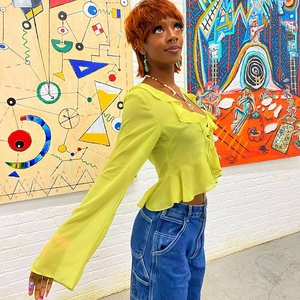 Chiffon ruffle top with deep V-neck and long sleeves paired with high-waist denim jeans