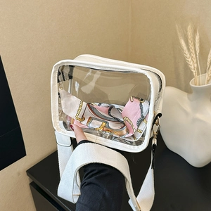 Transparent PVC crossbody bag with wide shoulder strap and pink silk scarf decoration