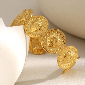 Détail d'un bracelet plaqué or 18 carats avec des breloques rondes fraises gaufrées