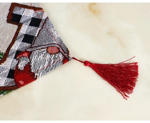 Detail of Christmas table runner featuring red silk tassels and jacquard weaving texture